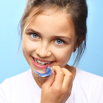 Young girl placing an orthodontic appliance