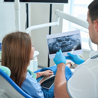 Closeup of orthodontist pointing to patient's X-ray