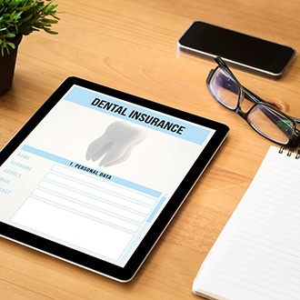 Dental insurance form on iPad next to office supplies on desk