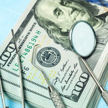 Dental tools lying on pile of money