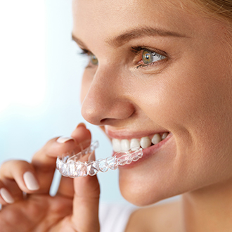 Closeup of patient placing Invisalign tray