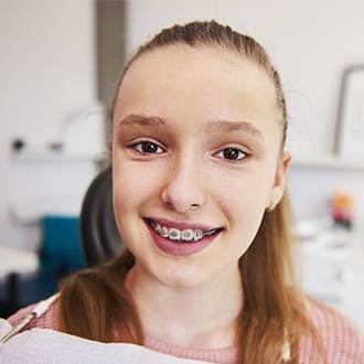 Smiling preteen girl with braces outdoors